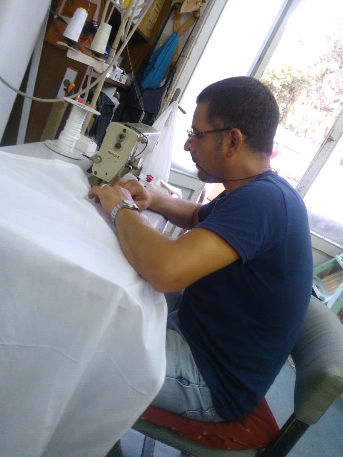 Alessandro confeziona un tendaggio alla macchina da cucire