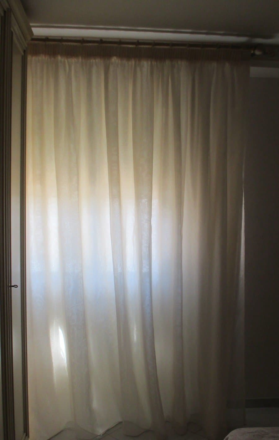 Voile avorio che filtra la luce della finestra