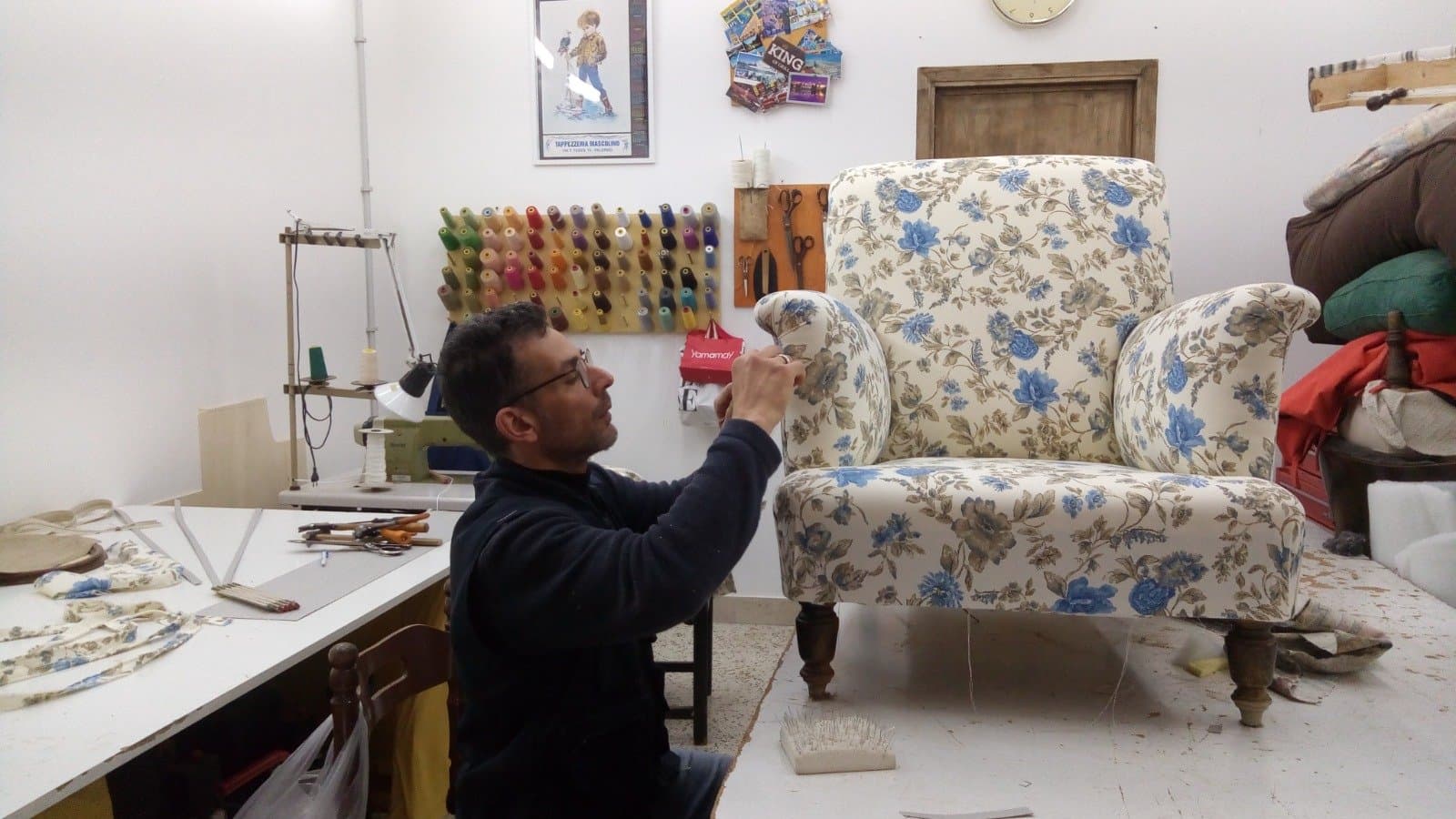 Alessandro Mascolino rifinisce una poltrona a fiori nel suo laboratorio