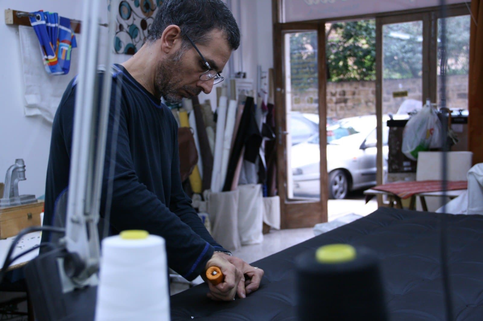 Alessandro Mascolino concentrato mentre segna la pelle sul banco di lavoro